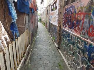 Fototapeta premium a narrow alleyway with murals on the walls in Yogyakarta Indonesia