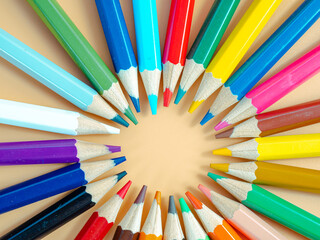Colored pencils on an orange background.