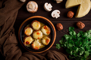 Traditional Georgian dish, appetizer, stuffed mushrooms, Sulguni cheese, baked in a Ketzi clay pan, on a wooden table, close-up, no people,
