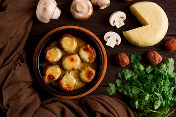 Traditional Georgian dish, appetizer, stuffed mushrooms, Sulguni cheese, baked in a Ketzi clay pan, on a wooden table, close-up, no people,