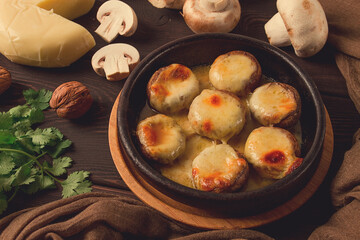 Traditional Georgian dish, appetizer, stuffed mushrooms, Sulguni cheese, baked in a Ketzi clay pan, on a wooden table, close-up, no people,
