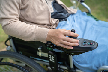Asian lady woman patient on electric wheelchair with joystick and remote control at nursing hospital ward, healthy strong medical concept