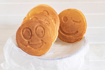 Pancake in the form of fun face for simple breakfast on white background.