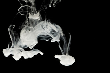 selective focus white liquid drop in clear water with lighting, look like smoke in the night.