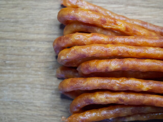 Traditional Polish sausages Kabanos on a wooden surface, macro photo. Kabanos, also known as cabanossi or kabana, is a long, thin, dry sausage usually made of pork which originated in Poland.
