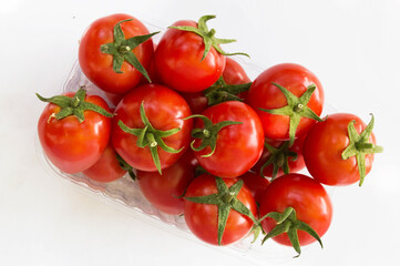 small red tomatoes in a transparent container on a white background.  Poster, billboard, advertising for supermarkets, stores.