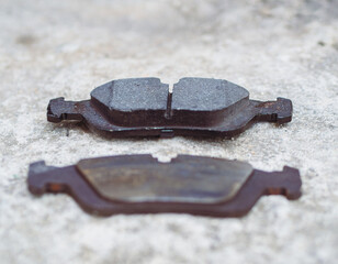 Comparing new and old worn brake pads from car braking system. Lack of proper maintenance of the...