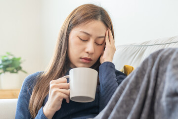 Sick, hurt or pain asian young woman, girl sore throat with glass, mug of warm water, headache have...