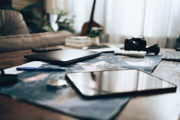 World map on the table. Laptop, tablet, camera, campass, pen and Tool of travel plan.