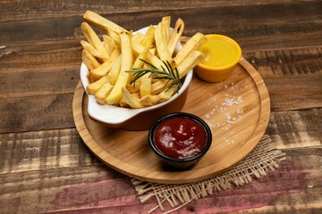 Tasty french fries on plate on bowl