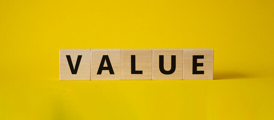 Value symbol. Concept word value on wooden cubes. Beautiful yellow background. Business and value concept. Copy space.