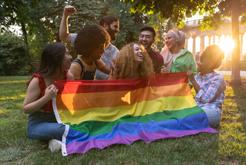 group of diverse people behind a gay pride rainbow flag, pride day celebrations. lgbtq