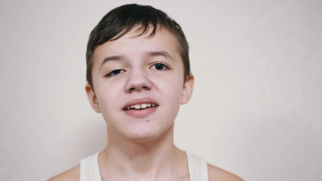 Irritated Child Screams loudly looking at the Camera. Portrait of an angry, screaming boy with an open mouth, a smirk on lips. Emotional outburst. Shock, stress. Release of negative emotions. Fury.