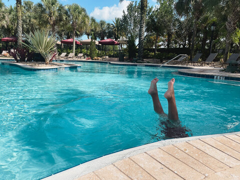 Young Boy With Legs Up In Blue Pool Underwater Hand Stand Resort Vacation Outdoors