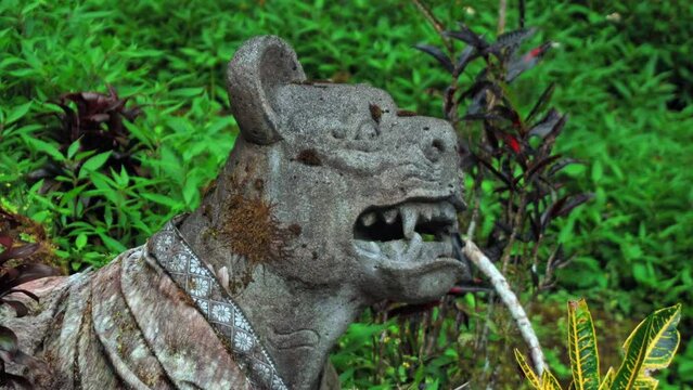 Stone statue of evil tiger standing in jungle with open mouth