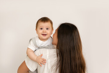 Happy young mother with her baby, little son in love on white background copy space. The concept of a happy family, motherhood. mother and child portrait
