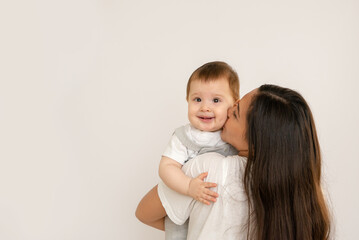 Happy young mother with her baby, little son in love on white background copy space. The concept of...