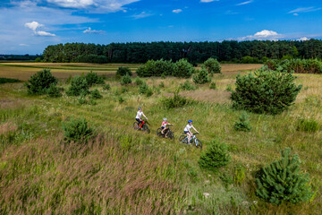 mother and kids on bikes cycling outdoors. active family sport and fitness together. drone photo. Family on bikes cycling outdoors