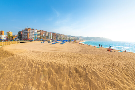 The wide sandy beach at the resort town of Lloret de Mar on the Costa Brava coast of the Mediterranean Sea in Southern Spain.