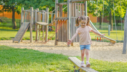 Little girl walks on a play on the park .