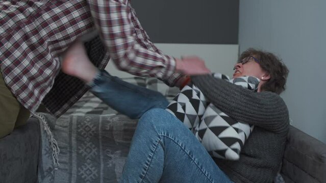 Woman is trying to protect herself from physical abuse of man at home. Male screams, threatens and humiliates female by holding her hair. The topic is domestic violence. The victim and the rapist. 