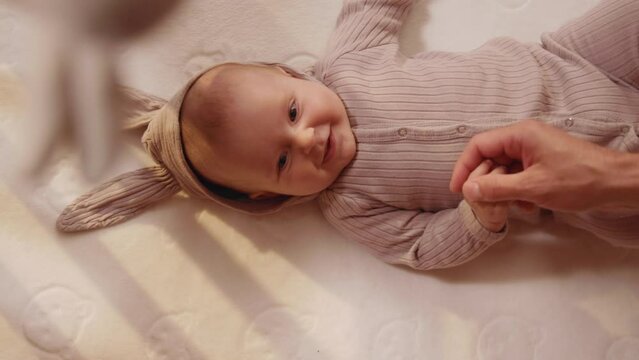 Happy charming newborn little cute hand reaching for father's loving finger. Baby holding parents finger. Smiling. Parentheses. Child. Slow motion