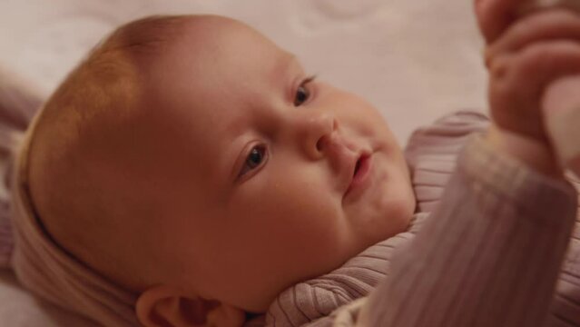 Close up shot of newborn little cute lying smiling play with father's hands stroking. Happy moment. Parentheses. Child. Slow motion