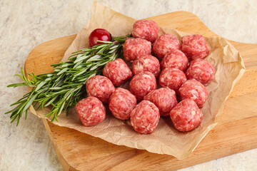 Raw uncooked beef meatballs served rosemary