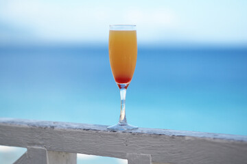  Delicious fruit cocktail with tequila on tropical beach. Ocean on background.