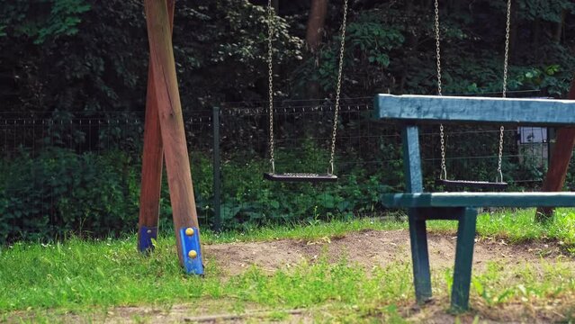 Empty Playground Swings With Plastic Seats Hanging on Metal Chain