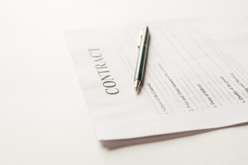 Fastened pages with legal documents and pen on white background.