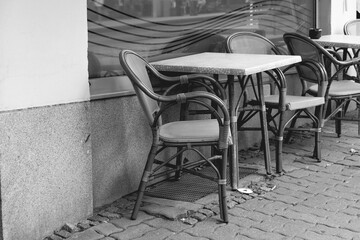 empty seats in front of a street cafe in a city