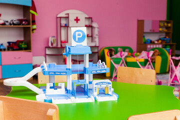On the green table is a children game in the form of a large parking lot for cars.
