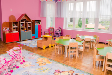 The interior of a group in a kindergarten with a lot of toys, educational games and bright furniture.