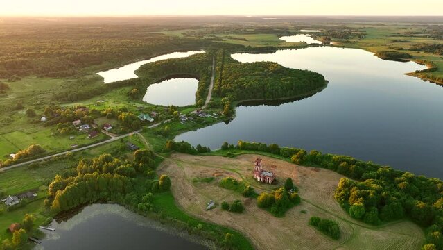 Lake in rural, aerial view. Freshwater Lakes. Abandoned Trinity Church in village of Belaya Tserkov. Lake Chereiskoye in Chereya village. Lighthouse on island. Panoramic landscape view of river.
