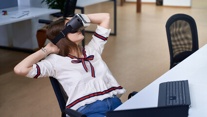 Female professional using vr virtual reality headset at desk in office