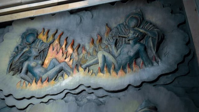 A painting on a wall in a Buddhist temple depicting hell. Torment of sinners. Servants of hell burn souls with fire in hell.