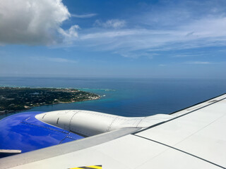 Southwest airplane wing flying above Cayman Islands getting ready to land on a bright blue sky sunny day.