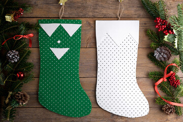Green and white Christmas stockings hanging against wooden wall background with Christmas...