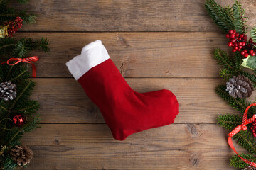Red Christmas stockings on a rustic wooden wall background with Christmas decoration, fir tree and...