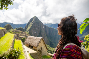 Woman Looking at Inca Citadel called Machupichu built of stones on the mountain, cloudy day, Peru - obrazy, fototapety, plakaty