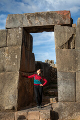 Tourist woman in the portico of the Inca ruins of Saqsaywaman in Cusco, Peru