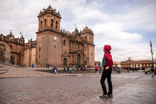 Tourist woman looking at cusco cathedral in plaza mayor, Peru