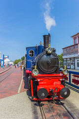 Fototapeta na wymiar Historic steam train locomotive in the center of Borkum village, Germany