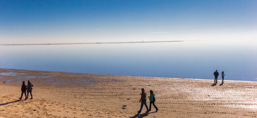 Fototapeta na wymiar People walking at the beach in Wilhelmshaven, Germany