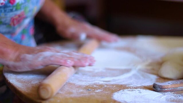 Women's hands in the process of cooking kutaba or chebureks, minced meat and onions in the dough. Azerbaijani, Tatar, Caucasian, Greek cuisine.