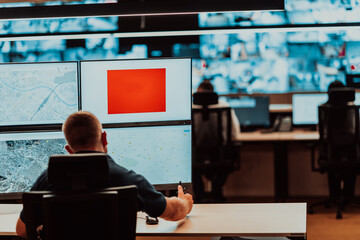 Male security operator working in a data system control room offices Technical Operator Working at...