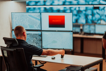 Male security operator working in a data system control room offices Technical Operator Working at...