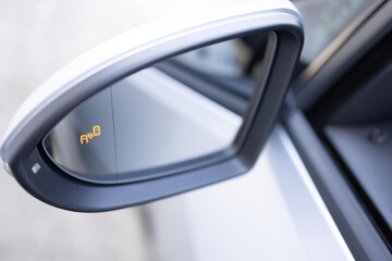 Blind zone monitoring sensor on the side mirror of a modern electric car. System blind spots of the...