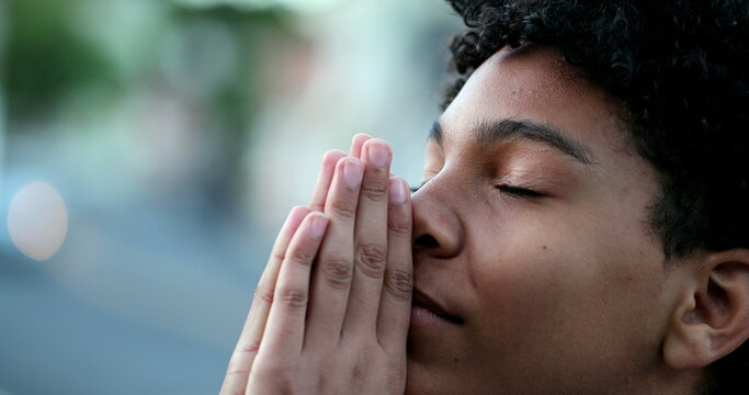 Child closing eyes praying. Spiritual kid prays with eyes closed